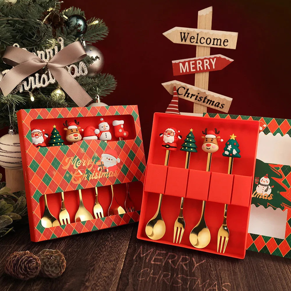 Four stainless steel Christmas spoons and forks with red handles showing Christmas tree and snowman designs on a white background