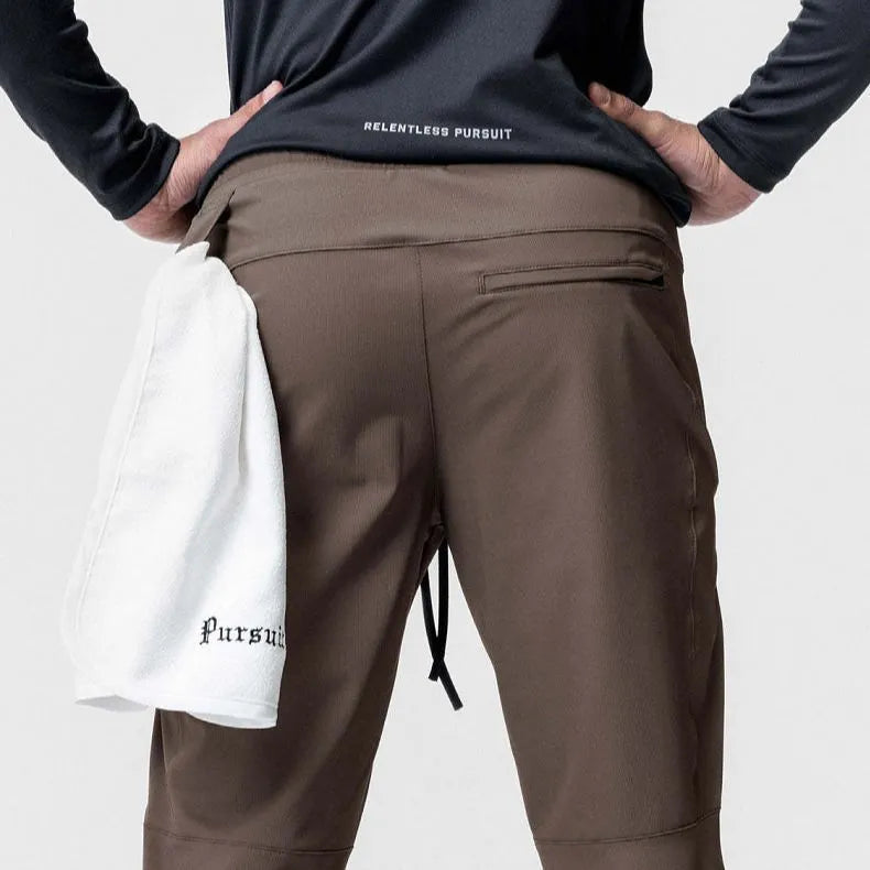 Men's grey quick-dry fitness trousers with ankle-tied design on exercise equipment