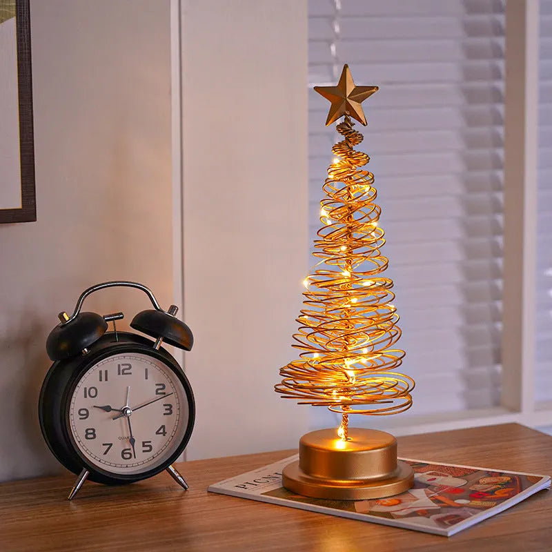 LED Christmas tree spiral light ornament with warm white glow on a table, gold finish