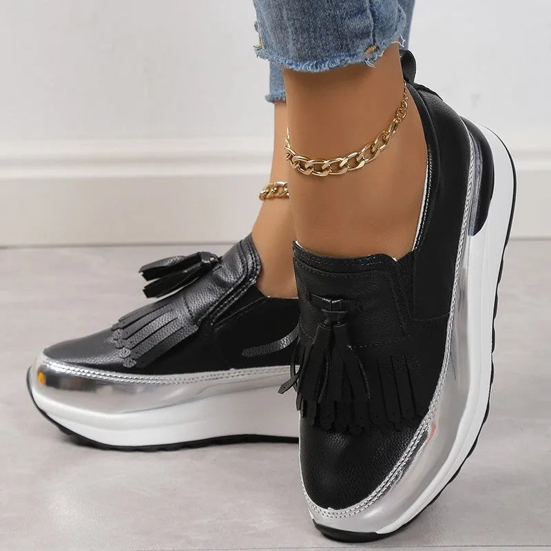 Women's black tassel platform casual shoe with wedge heel, low top, and round toe on a white background