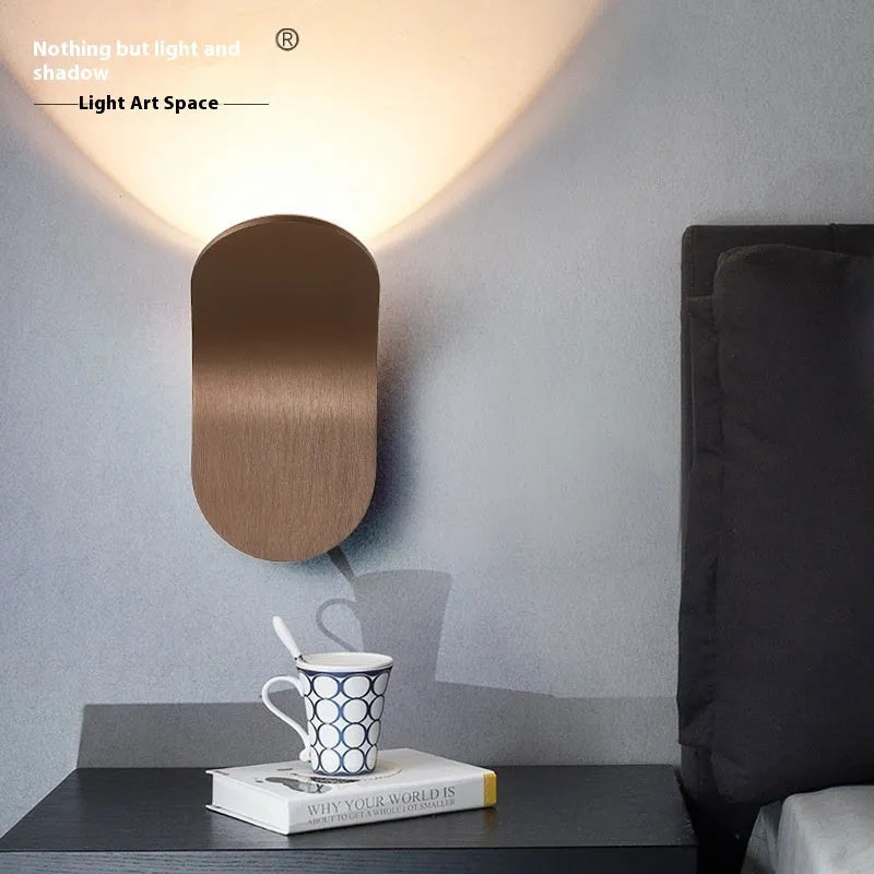 Modern simplicity wall light bulb in brushed black finish against a white wall