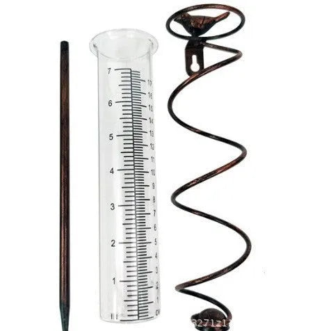 Hummingbird-shaped glass rain gauge on a cast iron base for garden precipitation measurement.