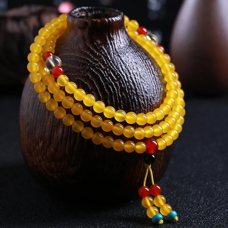 Polished crystal canary stone 108-bead geometric necklace with Lucky Cat detail on white background