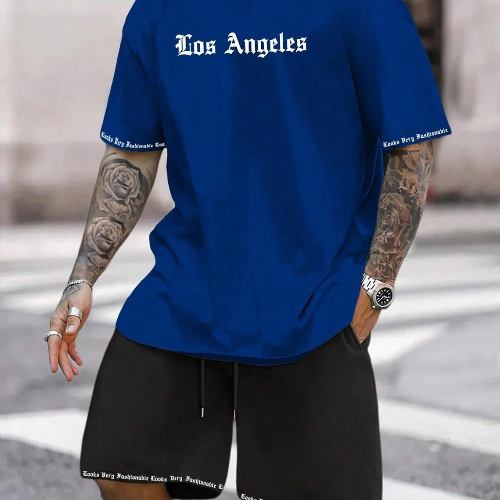 Man wearing a blue printed short-sleeved top and matching shorts from a sports-style two-piece set.
