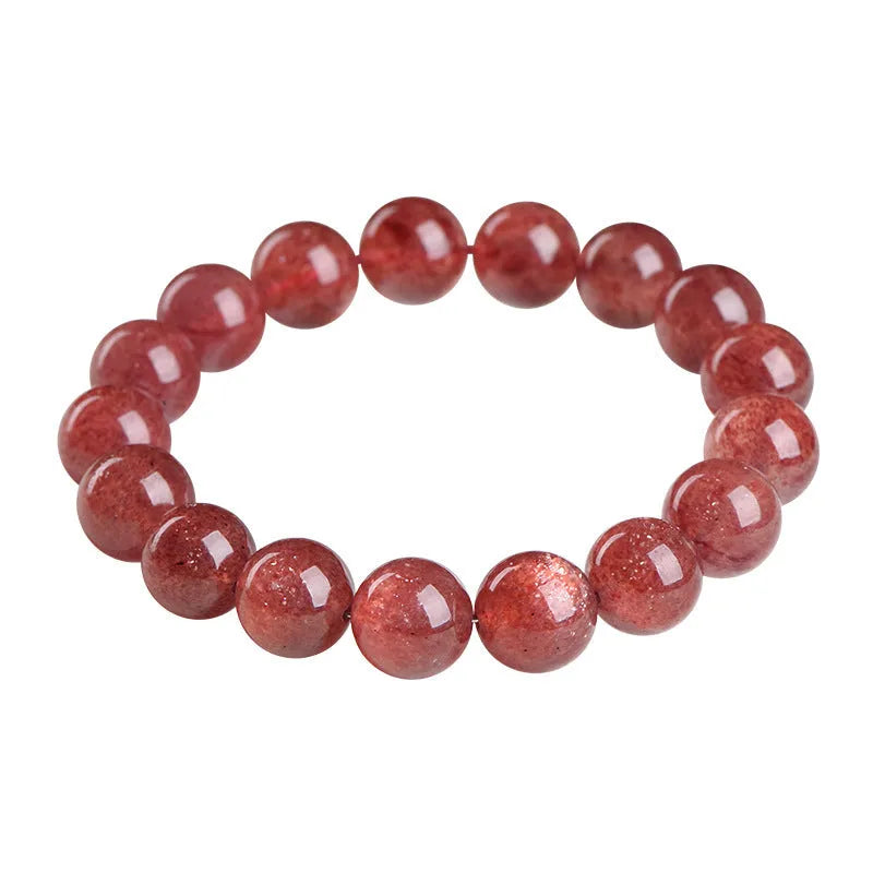 Natural red strawberry quartz crystal bracelet with geometric beads showing a starlight effect, laid flat.
