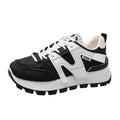 Low-top white and black casual sneakers with round toe and lace-up closure on a plain background.