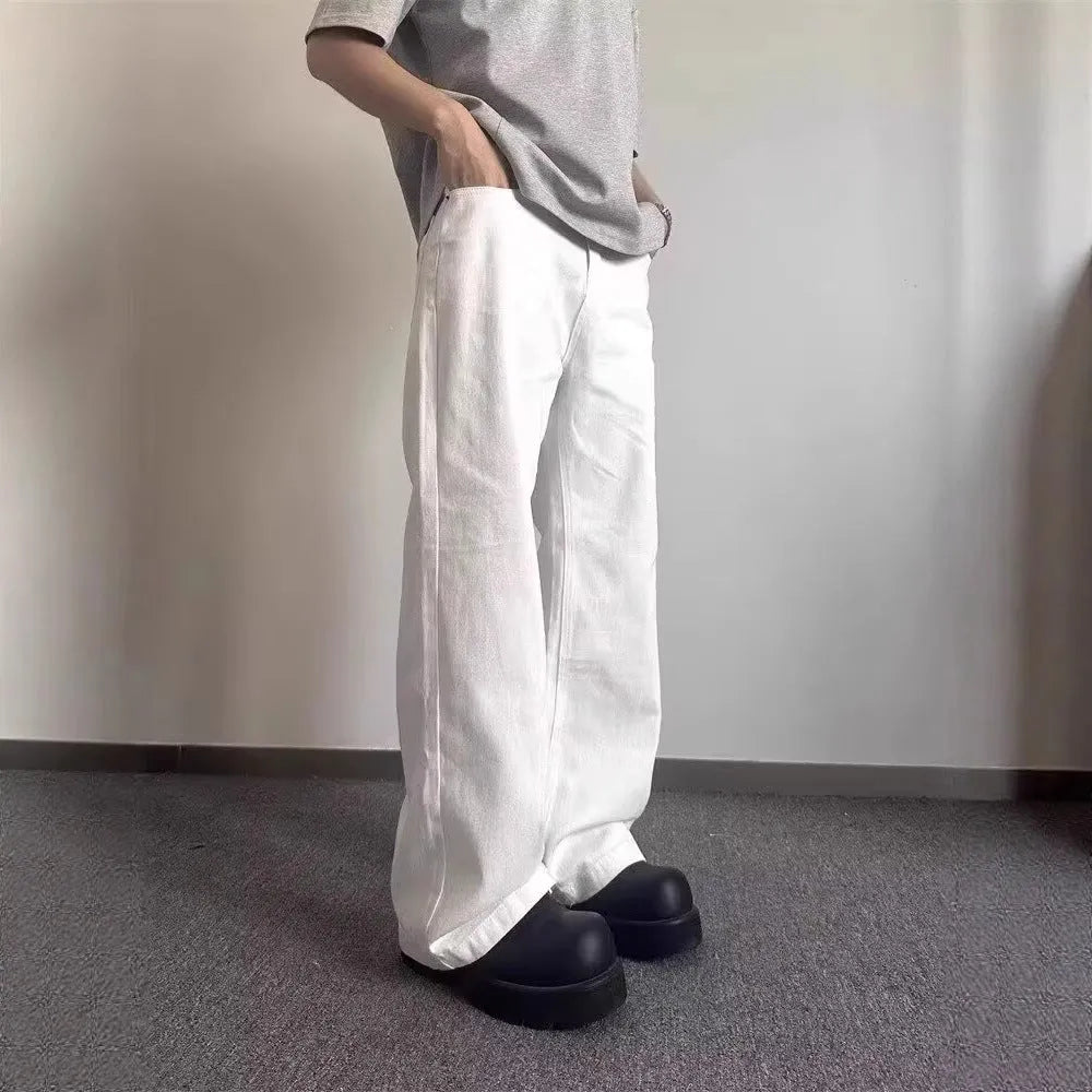 Men's white loose fit straight-leg cotton denim jeans on a plain background.