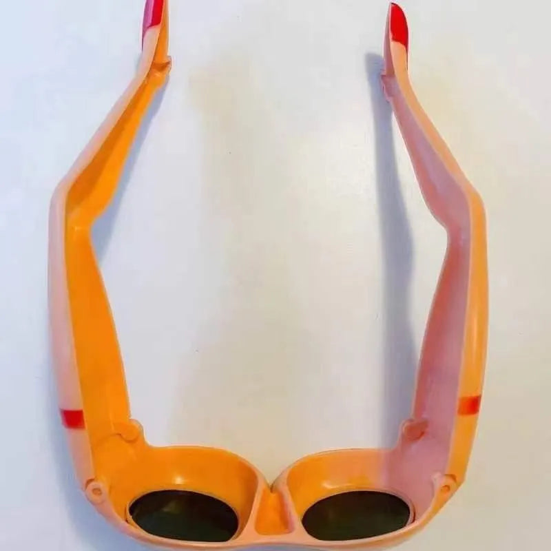 Orange plastic novelty sunglasses featuring a leg and hip design theme.