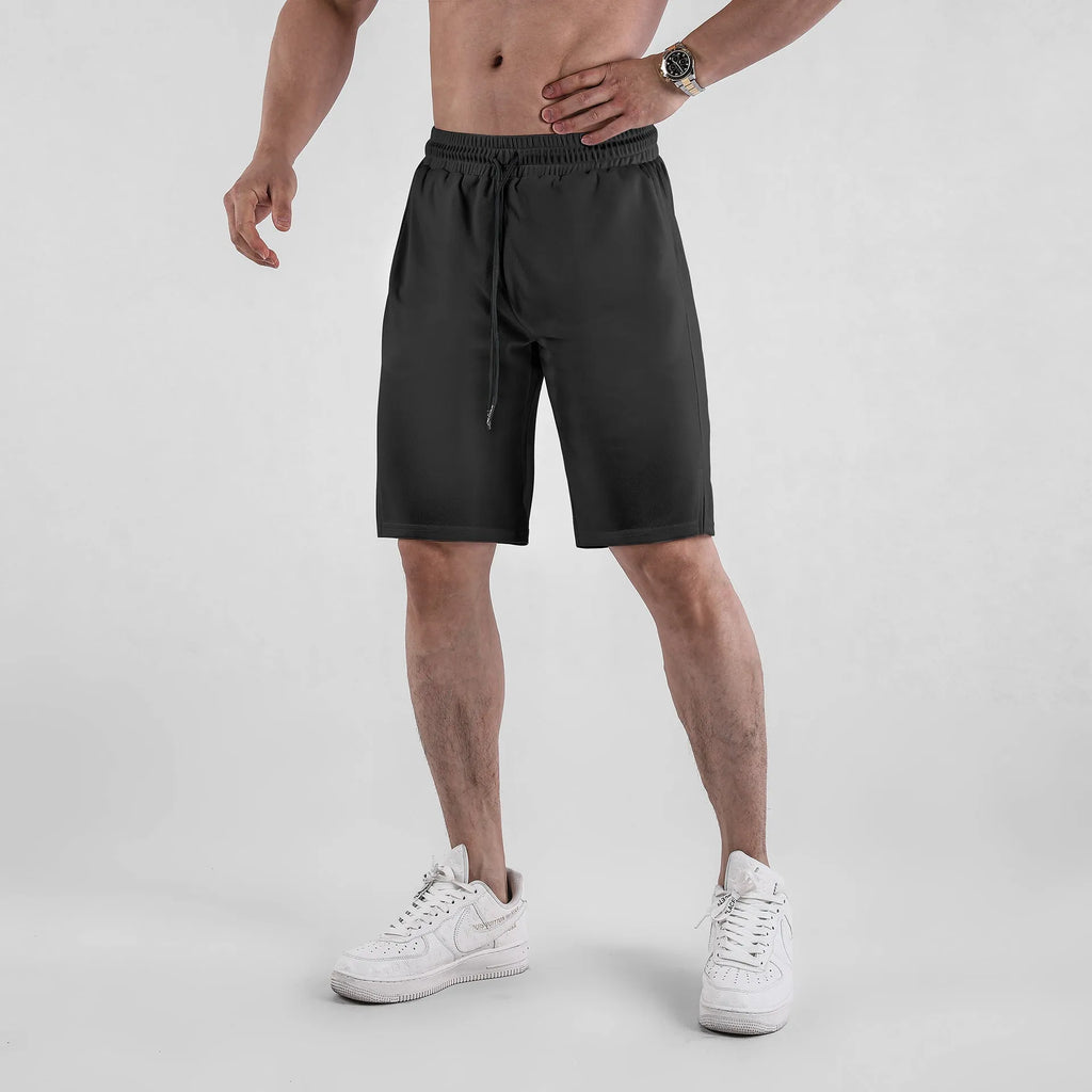 Men's black quick-dry mesh fitness shorts with elastic waistband laid flat.