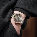 Stainless steel mechanical watch with round dial, transparent case back, and butterfly buckle