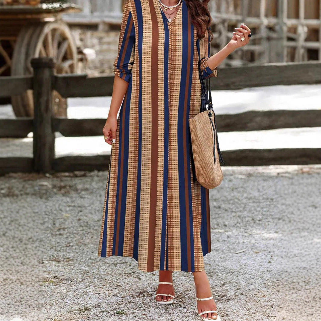Camel coloured knitted polyester dress with vertical stripes, V-neck, long sleeves, and an A-line skirt.