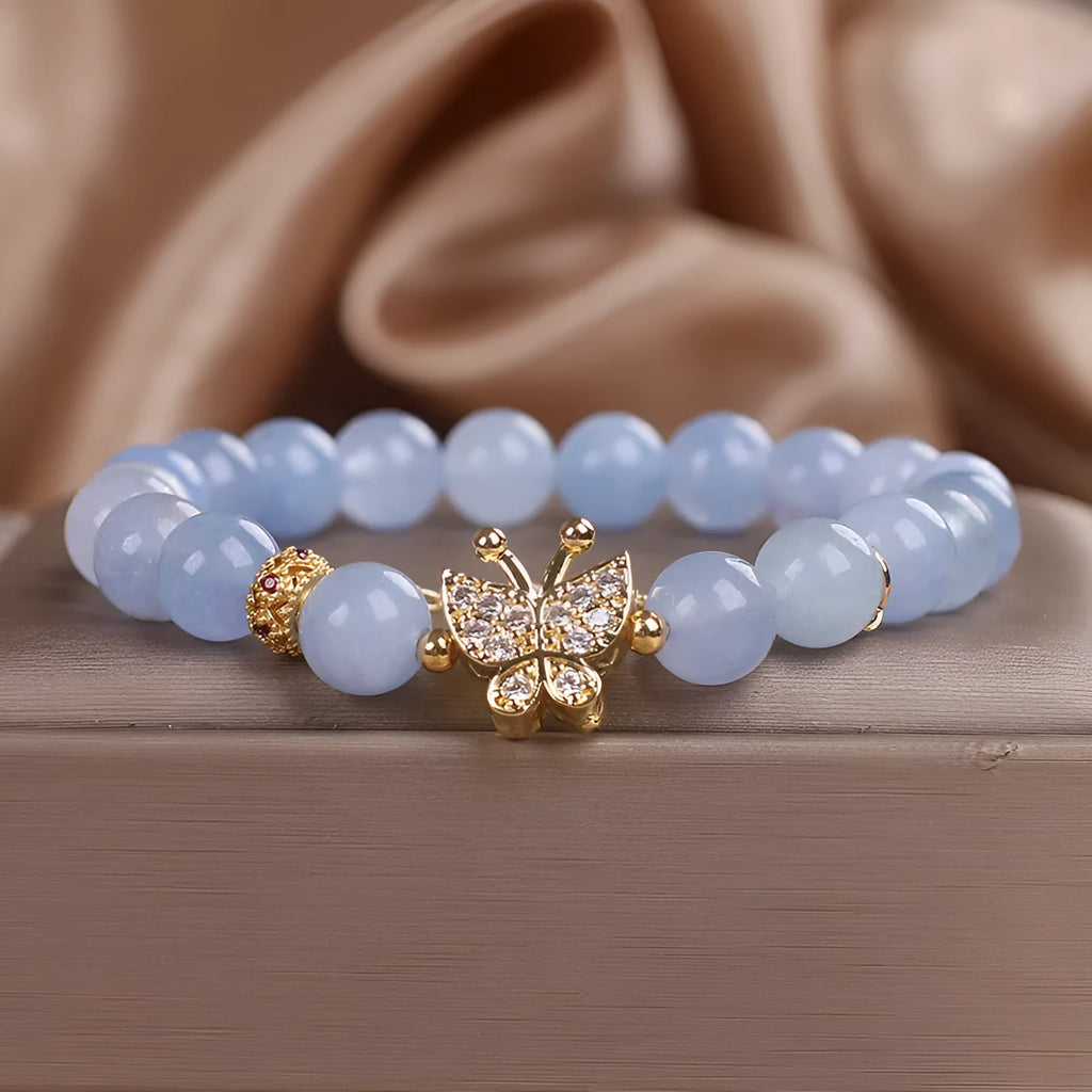 Sky blue crystal butterfly stretch bracelet for women with pearl and rhinestone accents on a plain background
