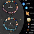 Set of twelve natural stone beaded bracelets laid out, each tagged with a different zodiac sign symbol.
