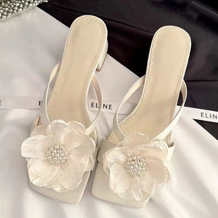 Women's chunky heel sandals with square toe, satin upper, and floral detail in cream-white.
