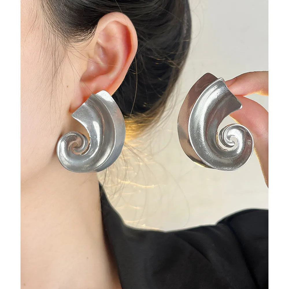 A pair of geometric-shaped alloy ear studs with a retro design, shown in gold and silver colours on a post backing.