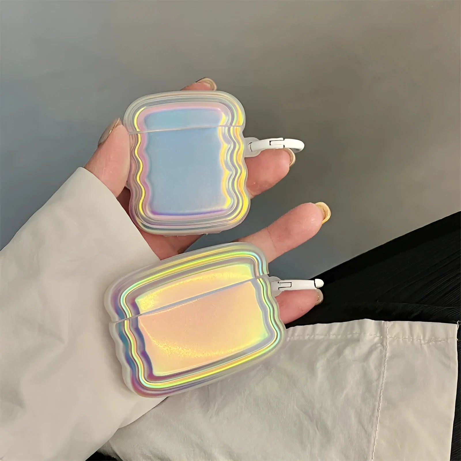 Silicone AirPods case with holographic laser ring design on a white charging case.