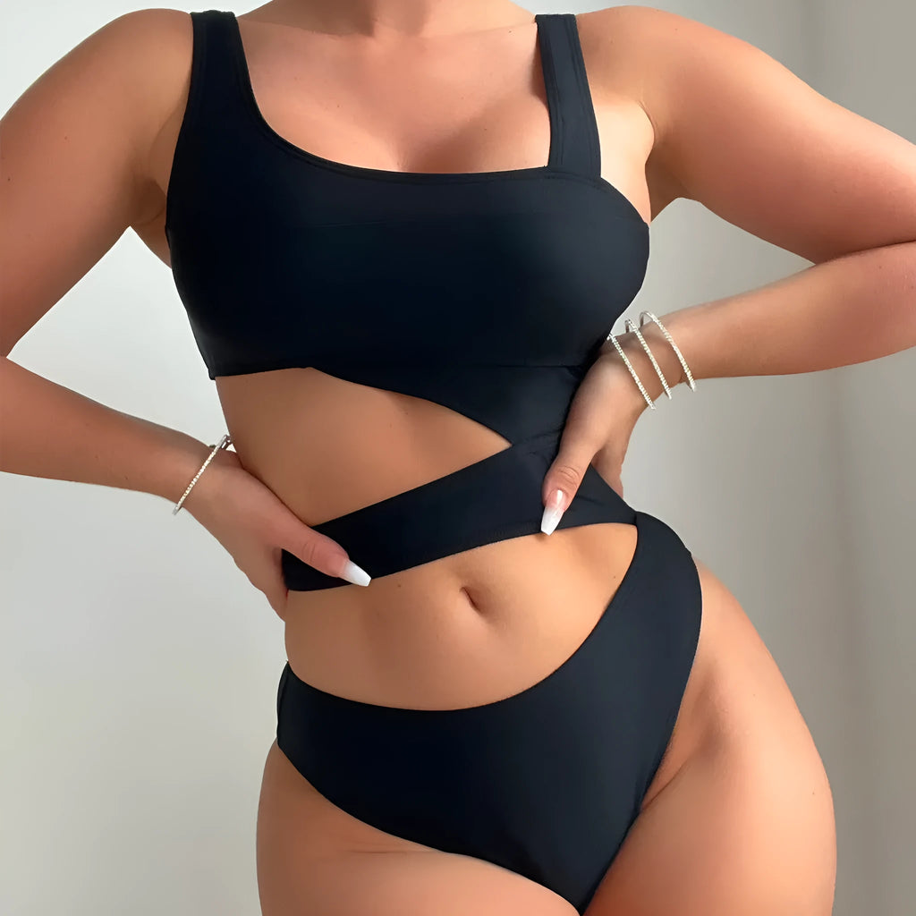Women's solid black one-piece swimsuit with hollow cut-out design and high-cut leg on display