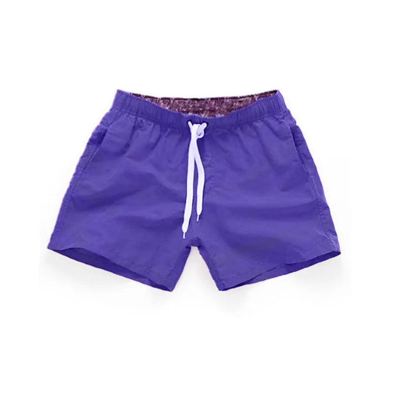 Men's straight-leg beach shorts in black polyester fabric on a size chart.