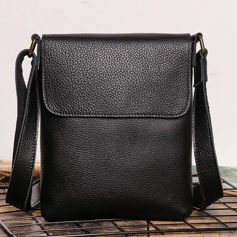 Men's genuine leather messenger bag in retro solid colour black shown on a table