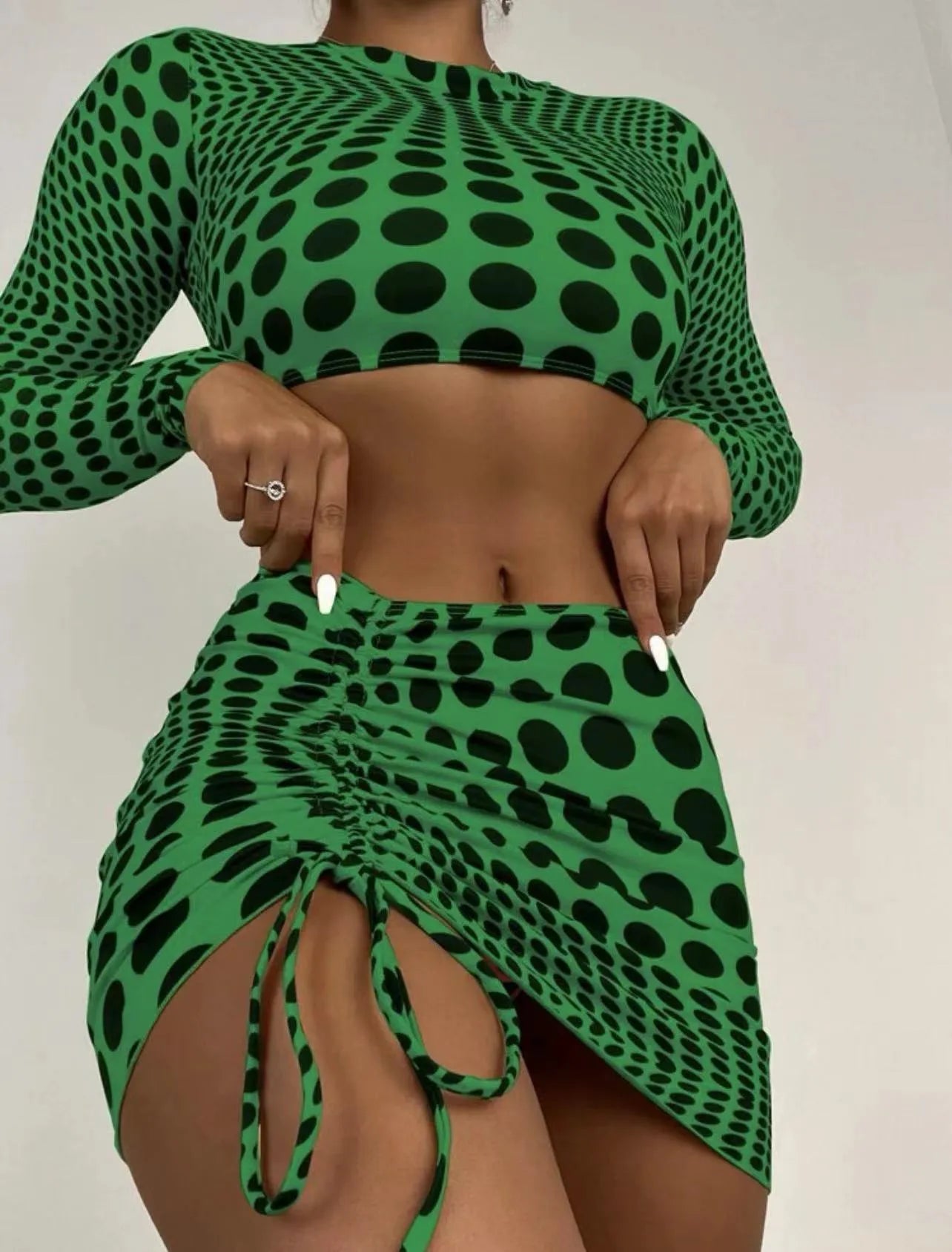 Women's green polka dot three-piece swimsuit set with top, skirt, and bra