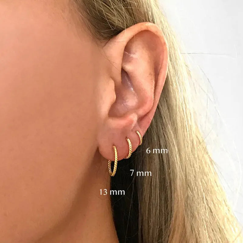 A pair of twisted string round geometric earrings made from Sterling Silver, shown in a gold electroplated finish.