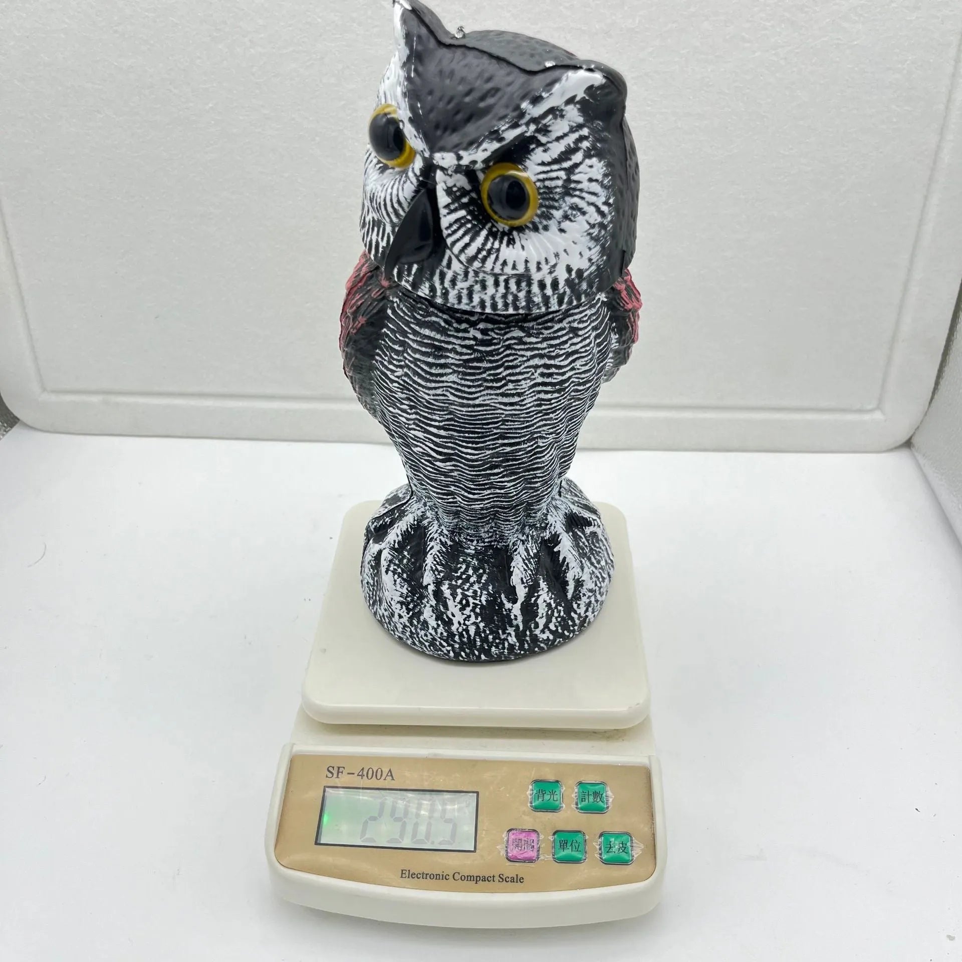 Artificial owl garden ornament with shaking head for bird deterrent on patio