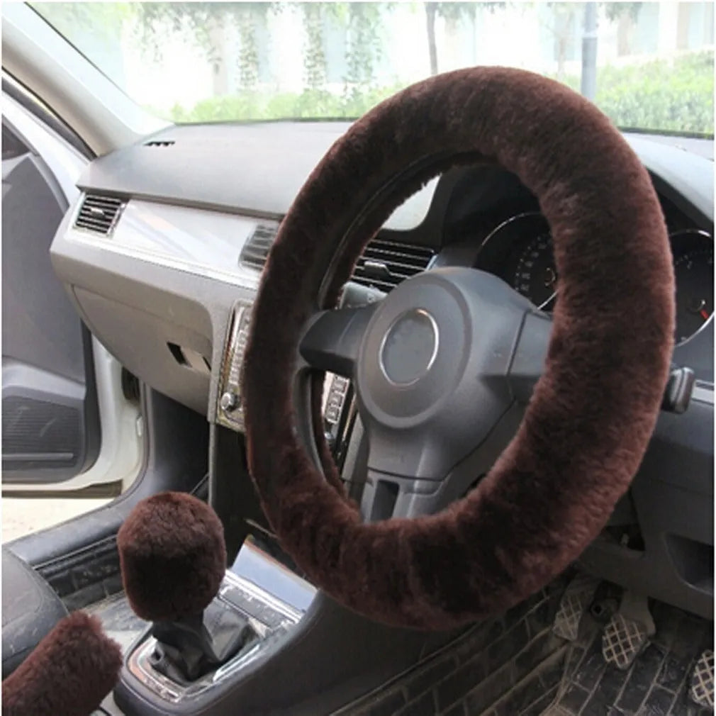 Winter plush car steering wheel cover set in black with matching gear shift and handbrake covers on a dark car interior