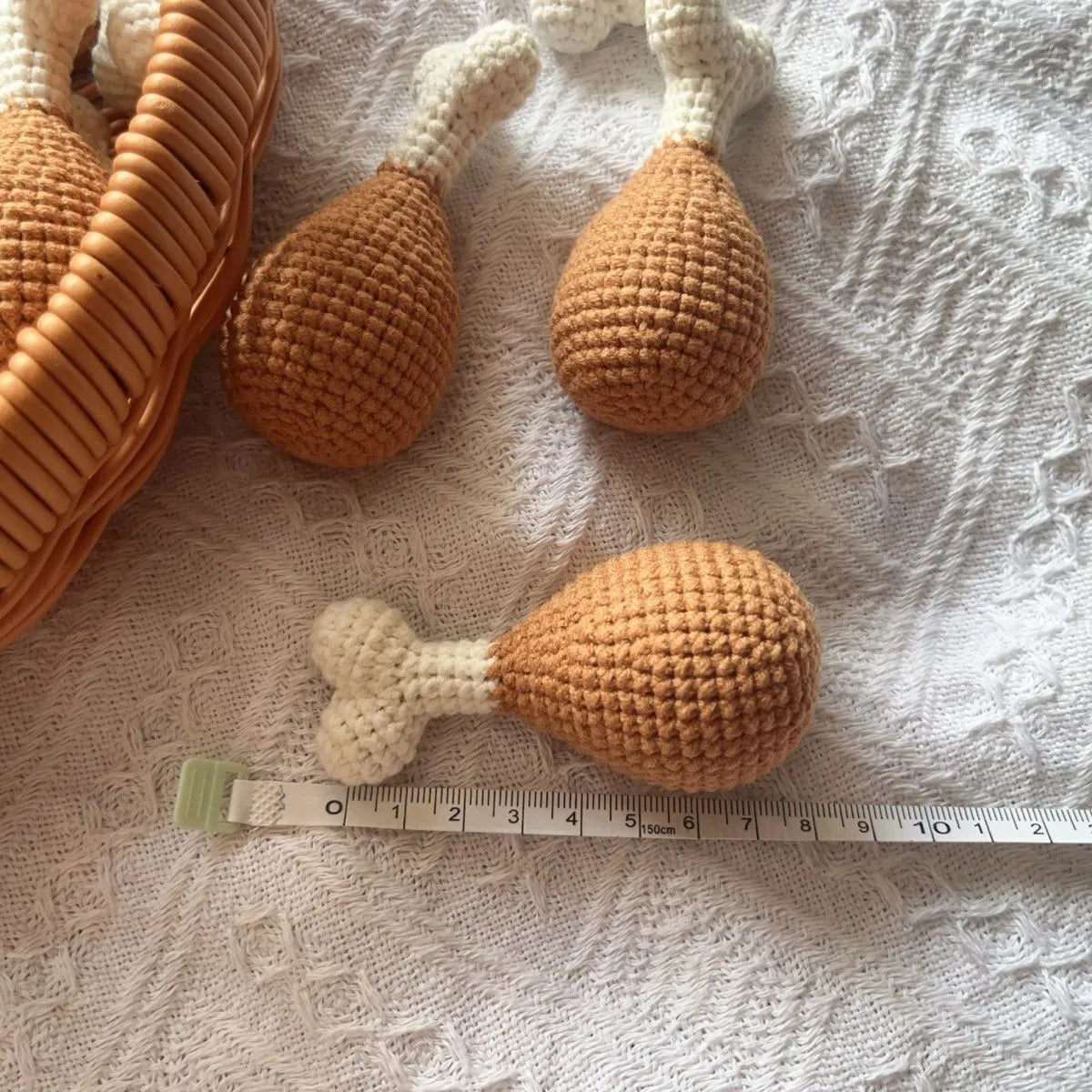 Crocheted chicken leg pendant key chain made of soft plush material, about 8 cm long, on a plain background