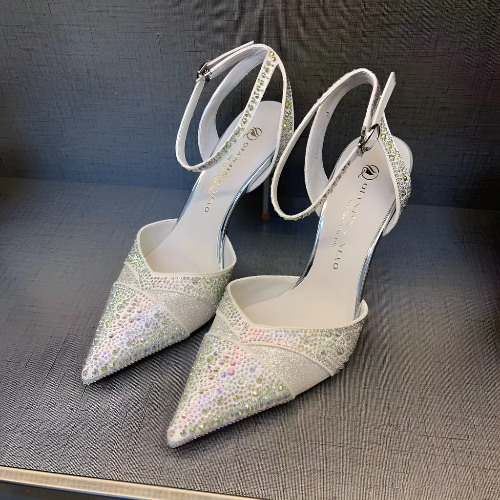 Women's black high heel shoe with pointed toe, stiletto heel, red sole, and hollow design detail.
