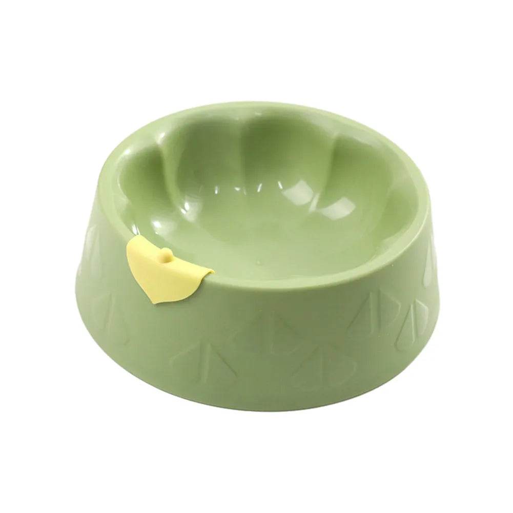 Green and yellow plastic double pet bowl for food and water on a flat surface.