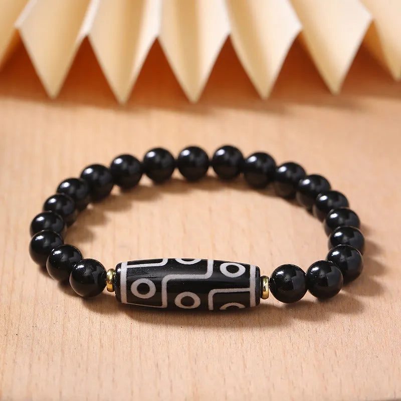 Ethnic style Tibet dzi bead bracelet in obsidian agate, unisex couple design on a neutral background
