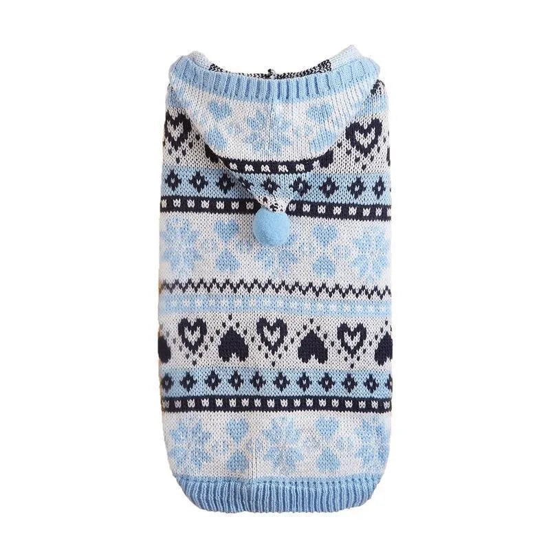 Blue knitted dog sweater with snowflake and camouflage patterns on a small white dog.