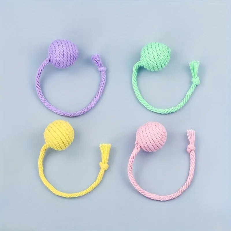 Colourful cat toy ball with attached rope and built-in bell in green, pink, purple, and yellow