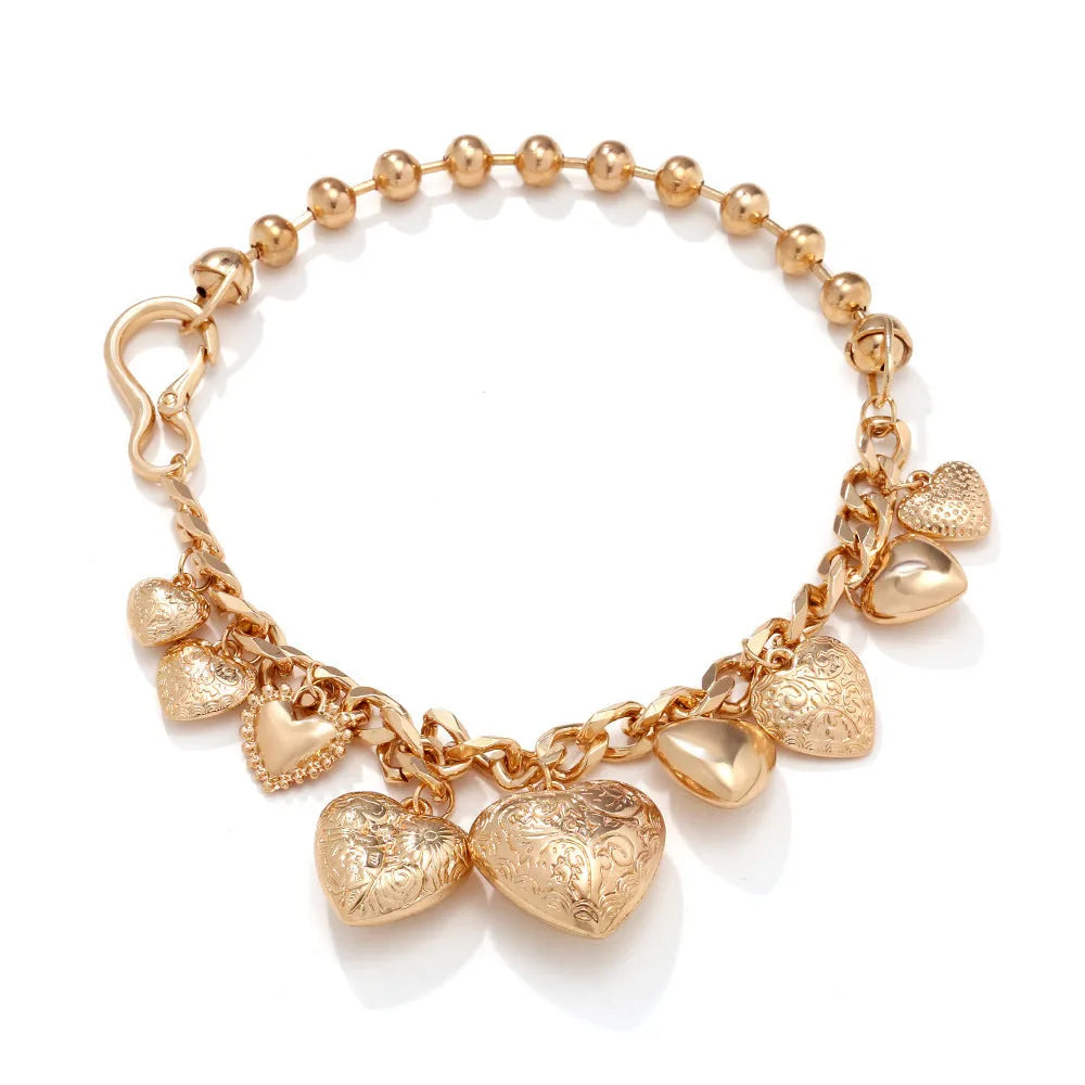 Carved heart-shaped pendant necklace on an adjustable metal chain in gold colour.