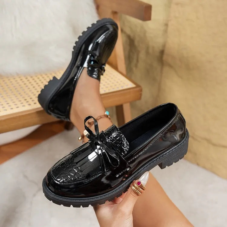 Women's brown loafers with a decorative bow on the front.