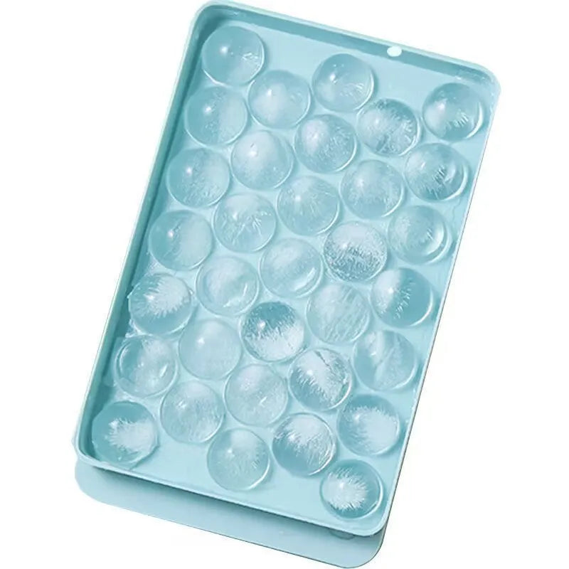 Blue silicone ice cube tray with lid showing 33 round moulds for large ice