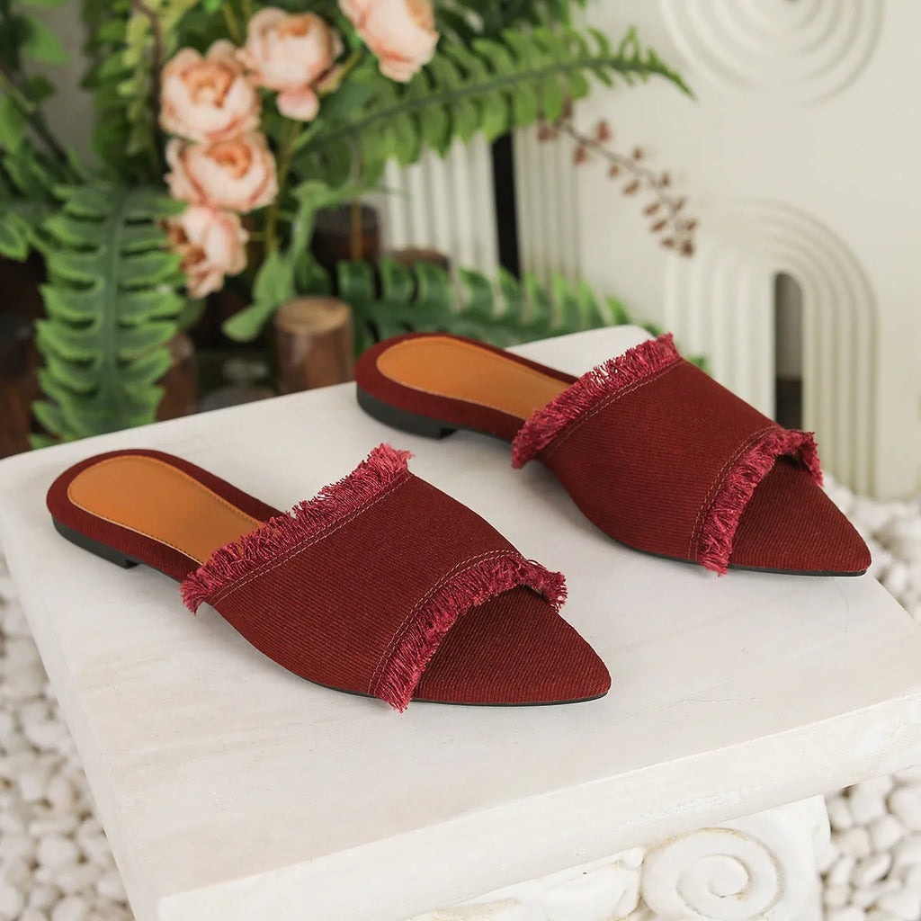 Women's denim flat slippers with tassel detail and leather lining in multiple colour options.