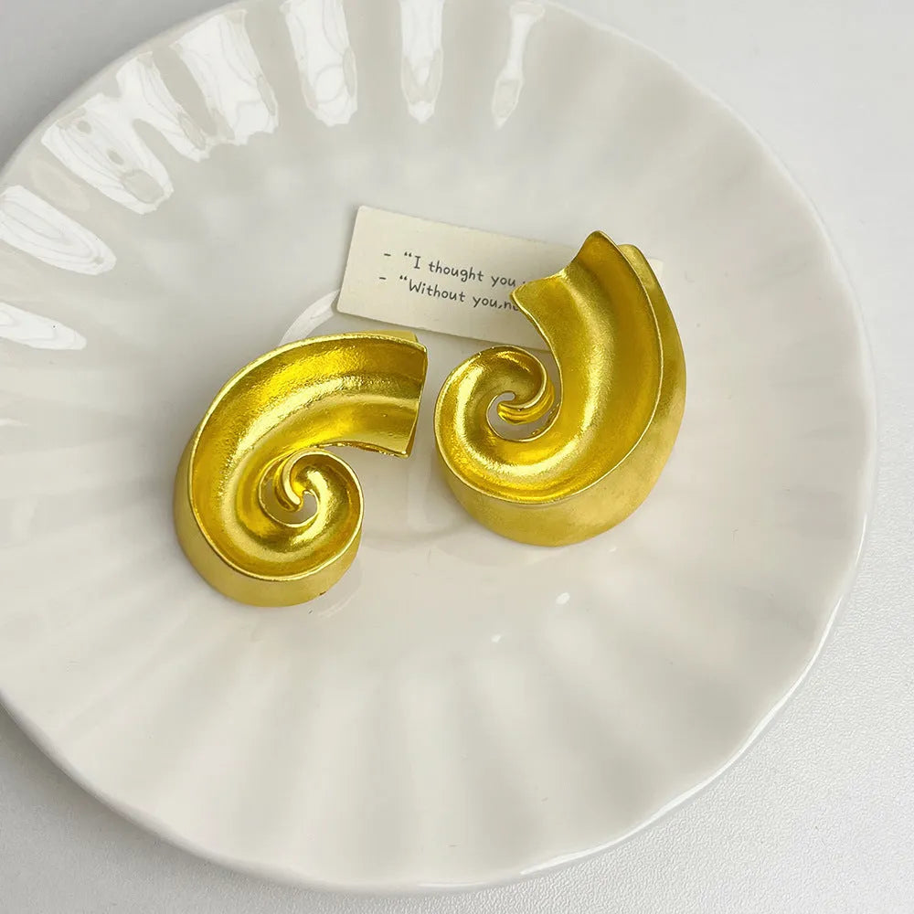 A pair of geometric-shaped alloy ear studs with a retro design, shown in gold and silver colours on a post backing.