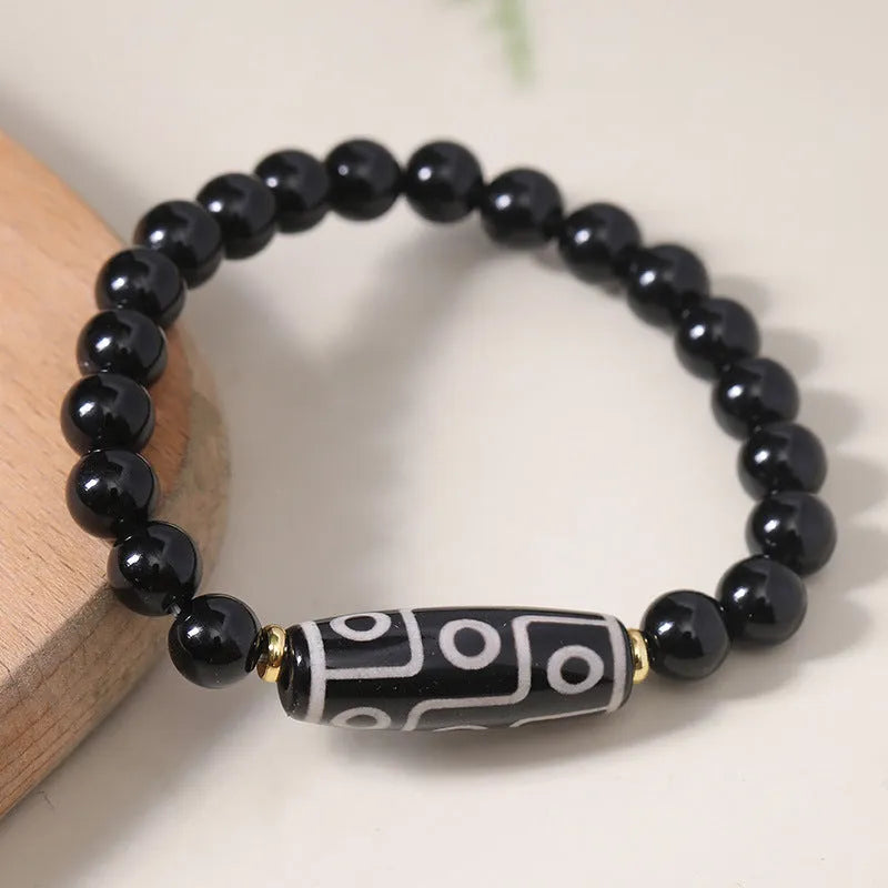 Ethnic style Tibet dzi bead bracelet in obsidian agate, unisex couple design on a neutral background