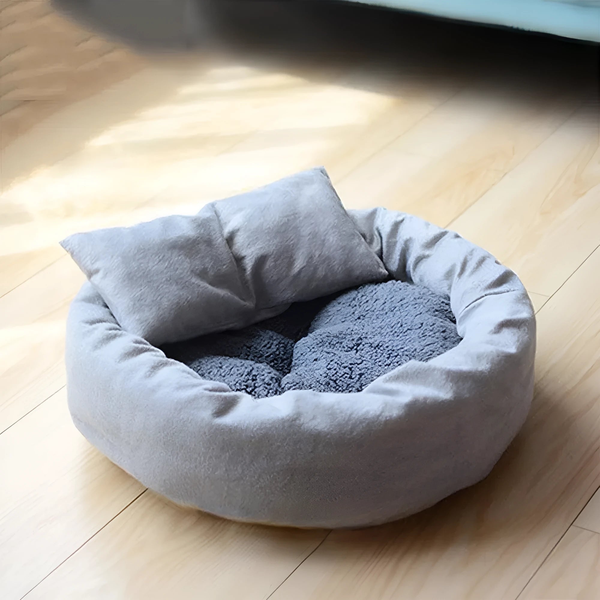 Round grey dog bed with fluffy rim and matching pillow on a non-slip Oxford cloth base.