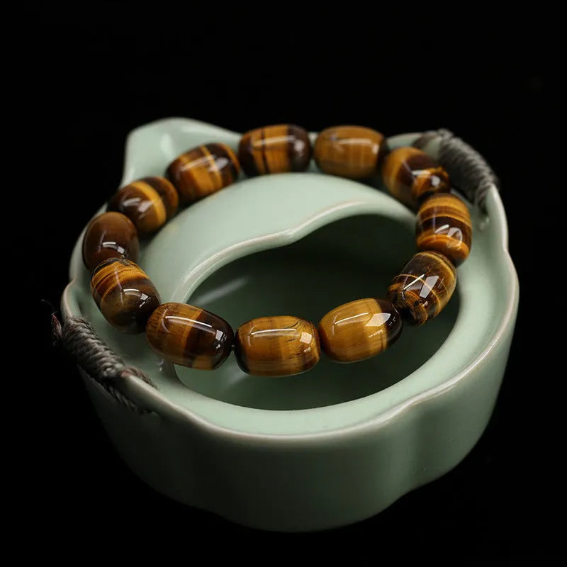 Natural yellow tigereye bracelet with sunny cat eye effect, ball beads in 11x16mm size on light background
