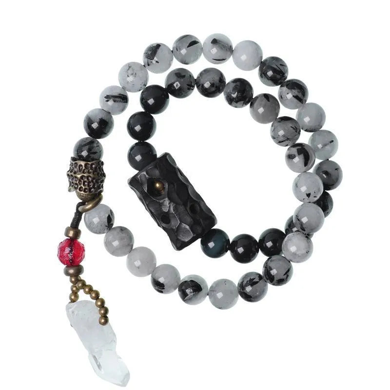 Black hair crystal bracelet with white crystal tassel and bending and lacing design on neutral background
