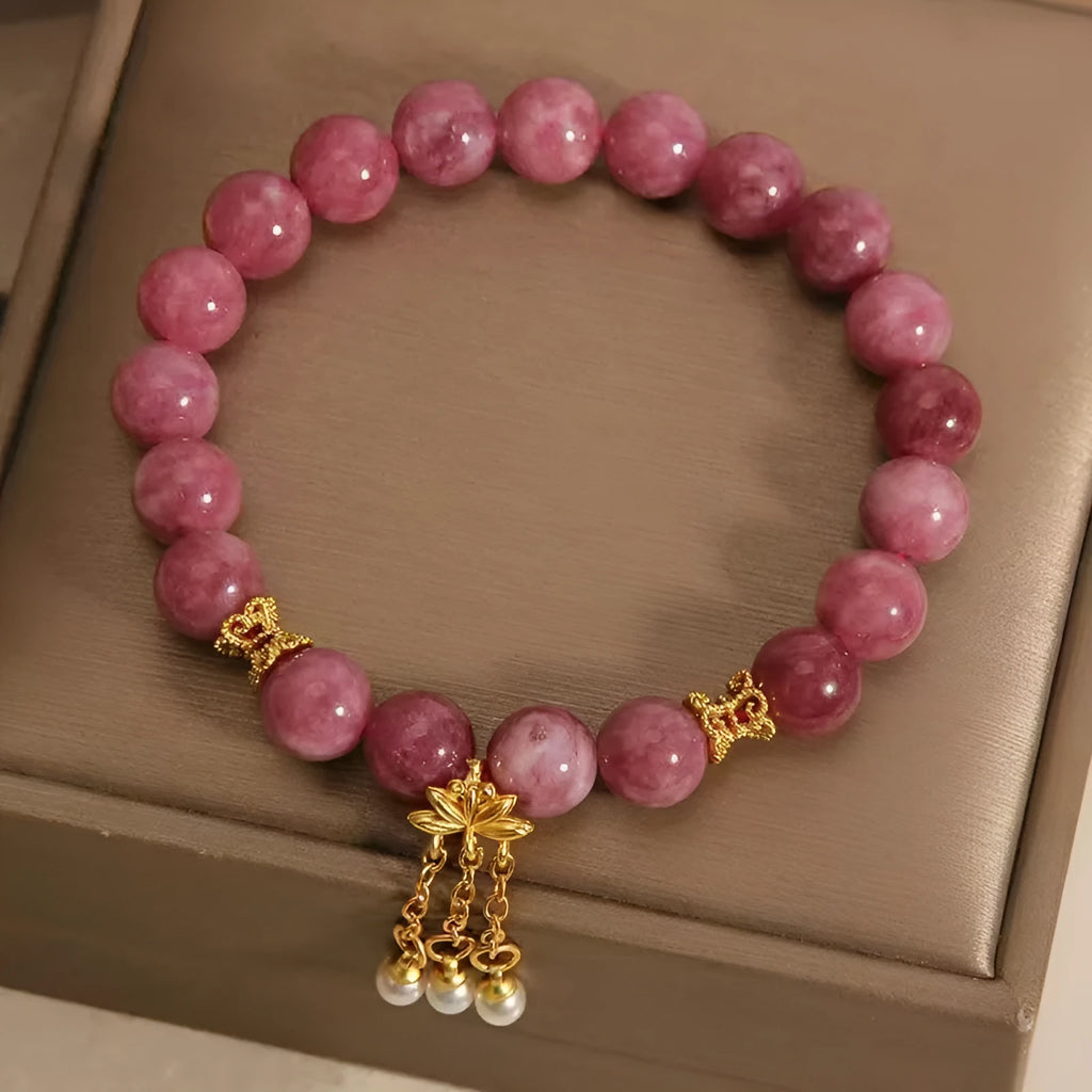 Natural stone beaded bracelet with pink lotus tassel, pearl pendant, and electroplated crystal beads on white background