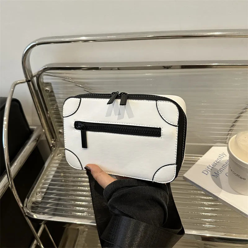 Women's small square PU crossbody bag in black with sewing line detail, single shoulder strap, and external pocket