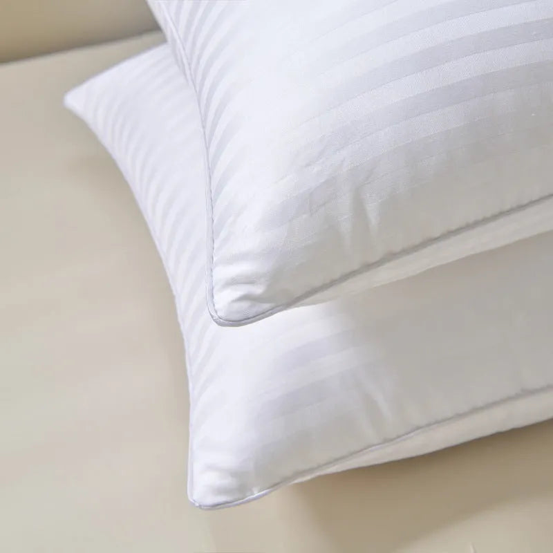 White cotton satin stripe pillow with feather and cotton filling shown in adult bedding setting.