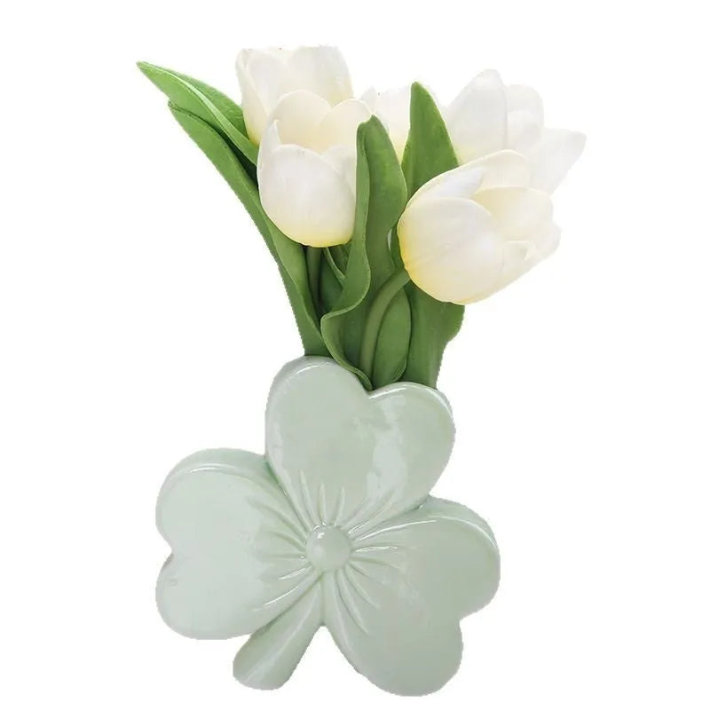 White porcelain clover ceramic vase in European style on a desktop.