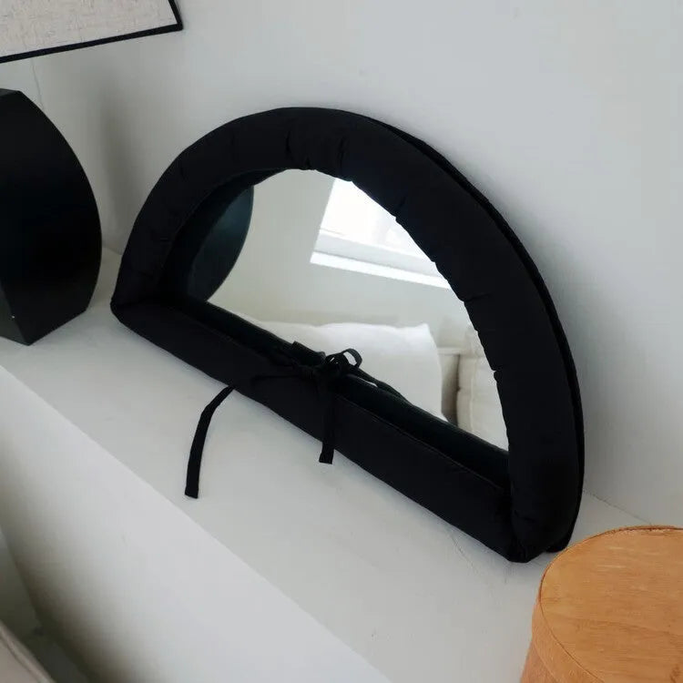 Soft cotton-filled fabric mirror in solid colour hanging as a background prop