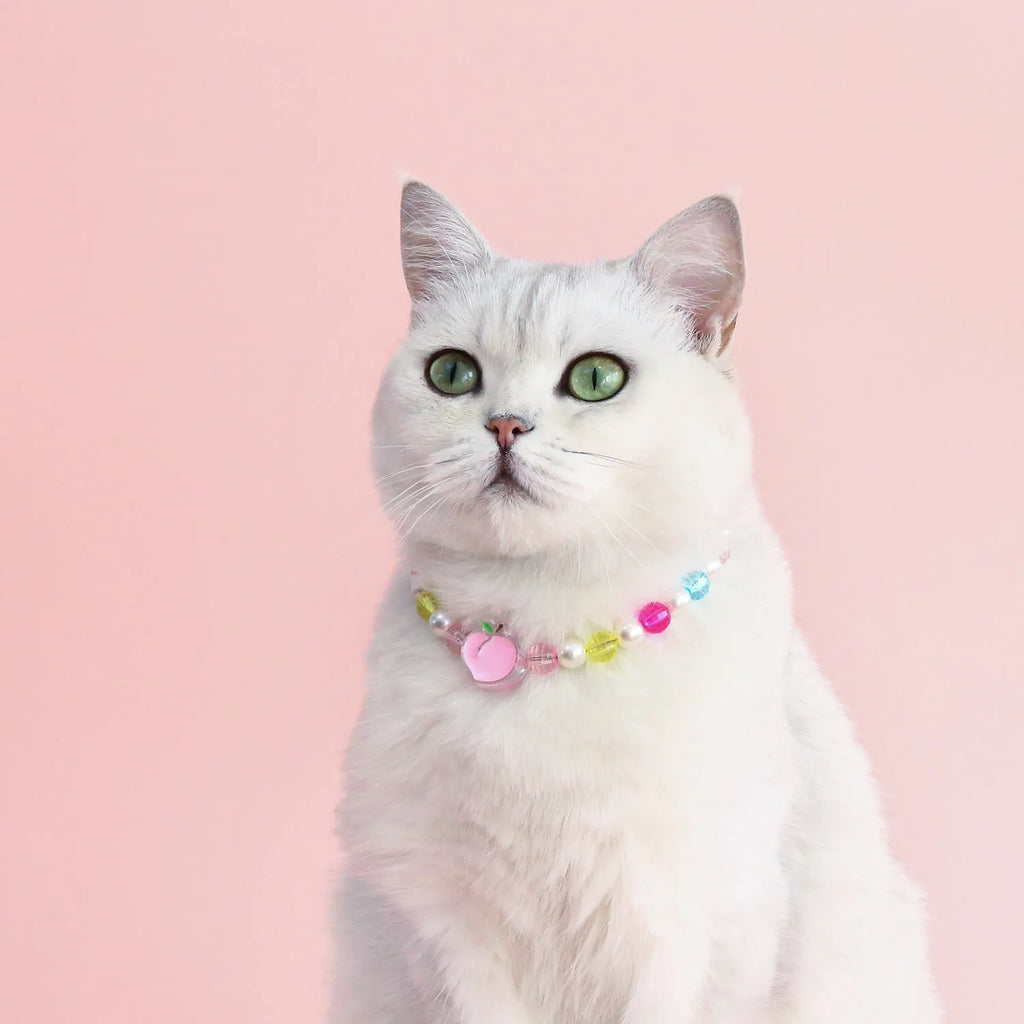 Adjustable plastic cat collar necklace with colourful pearl beads in small flower, rainbow, or peach patterns.